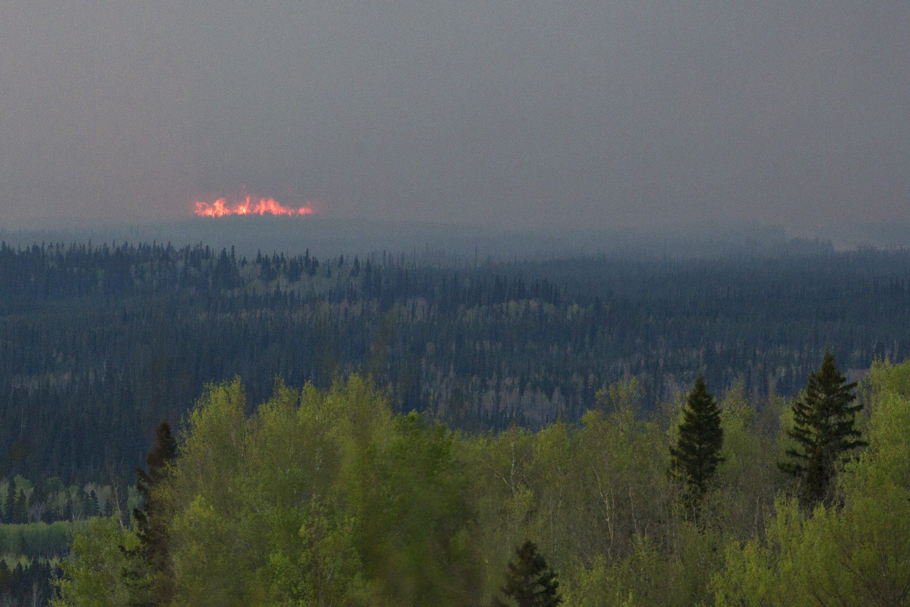 A wildfire flares up near Fort McMurray, Canada, Thursday, May 5, 2016. Canadian officials will start moving thousands of people from work camps north of devastated Fort McMurray in a mass highway convoy Friday morning if it is safe from the wildfire raging in Alberta. (Jason Franson/The Canadian Press via AP) MANDATORY CREDIT