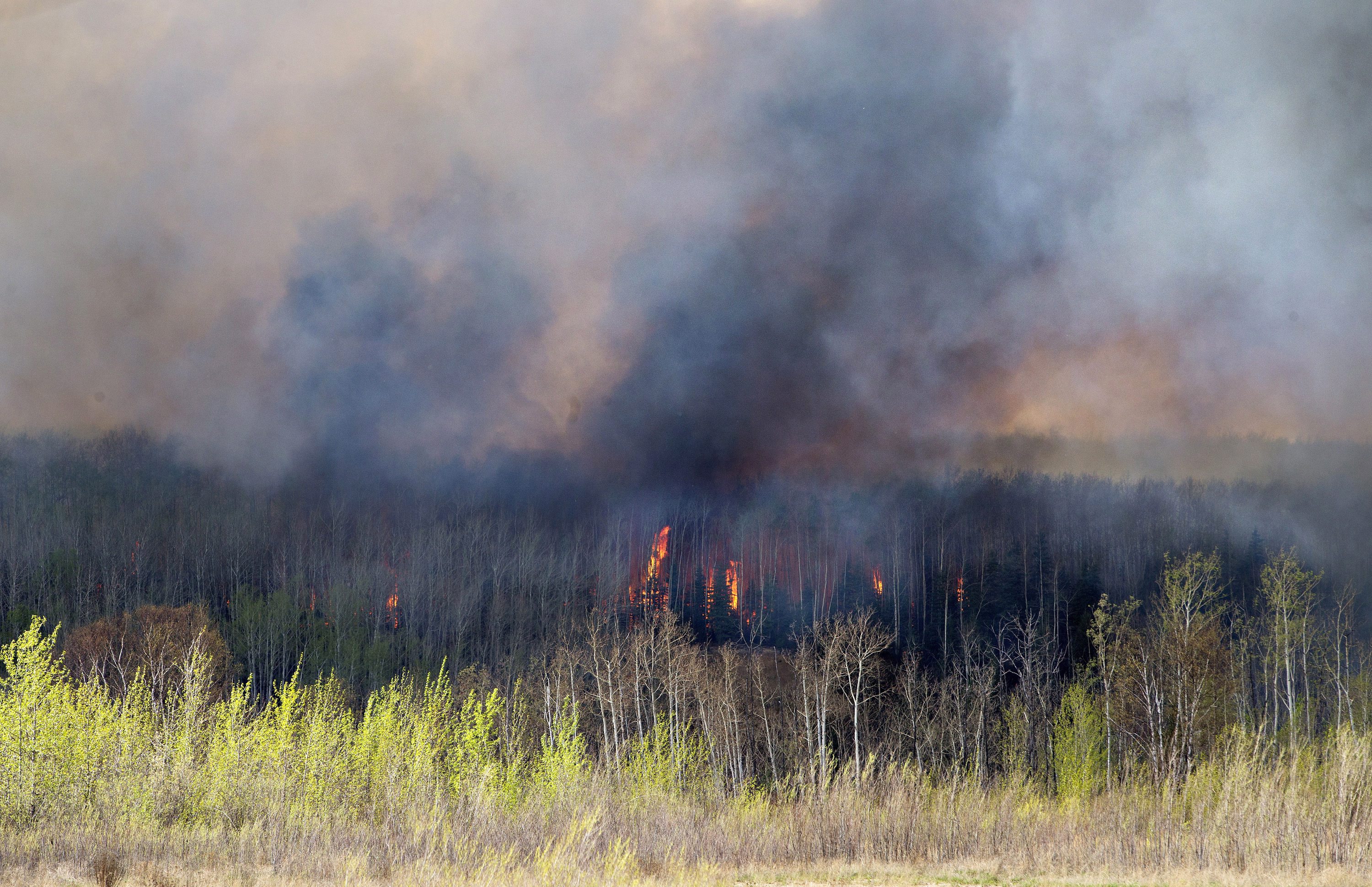 A wildfire rages through Fort McMurray, Alberta, Wednesday, May 4, 2016. The raging wildfire emptied Canada's main oil sands city, destroying entire neighborhoods of Fort McMurray, where officials warned Wednesday that all efforts to suppress the fire have failed. (Jason Franson /The Canadian Press via AP) MANDATORY CREDIT