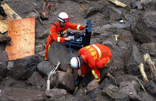 Rescuers use detectors to scan for potential survivors at the site following a landslide in Taining county in southeast China's Fujian province, Sunday, May 8, 2016. Rescuers on Sunday searched for 34 construction workers missing in a landslide at the site of a hydropower project following days of heavy rain in southern China. Seven other workers were pulled out alive, officials and state-run media reported. (Chinatopix via AP) CHINA OUT