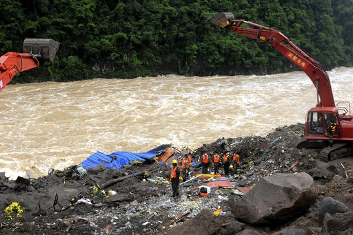 Rescuers pay respect to a body of a victim found at the workers' dormitory damaged by a landslide in Taining county in southeast China's Fujian province, Monday May 09, 2016. Rescue teams have recovered dozens bodies while 25 people are still listed as missing Monday following a landslide at the site of a hydropower project in southern China after days of heavy rain, authorities said. (Chinatopix via AP) CHINA OUT