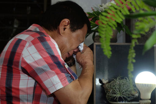 In this photo provided by Davao City Mayor's Office, leading presidential candidate Mayor Rodrigo Duterte wipes his tears as he visits the tomb of his late father Gov. Vicente Duterte at San Pedro Memorial Park in Davao city, southern Philippines early Tuesday, May 10, 2016. Soon after it became clear from the election count that Davao City Mayor Duterte will be the next president of the Philippines, he left his home at 3 a.m. Tuesday and went to the cemetery. At the tomb of his parents, he kneeled. And he wept. (Kiwi Bulaclac, Davao City Mayor's Office via AP)