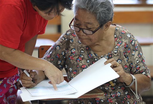 80-year-old Filipino Dioleta Esteban, right, is assisted as she votes at a polling center in suburban San Juan, east of Manila, Philippines Monday May 9,2016. (AP Photo/Aaron Favila)