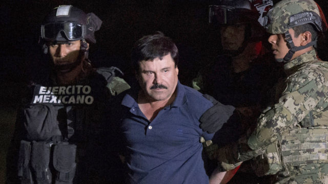Joaquin El Chapo Guzman in handcuffs being escorted by the police
