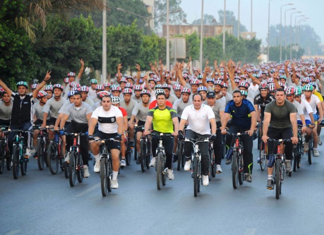 Egypt's President Abdel Fatah al-Sisi (3rd right, in white) rides a bicycle with hundreds of Egyptians behind him. Note Sisi and his entourage are uniformly helmletless while everyone behind them is wearing one of three designs. (Reuters)