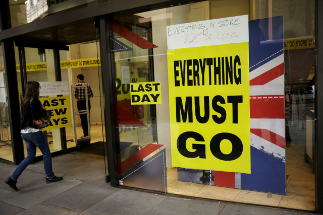 A store closing sale banner stating "Everything Must Go" on a window next to the colors of the Union flag