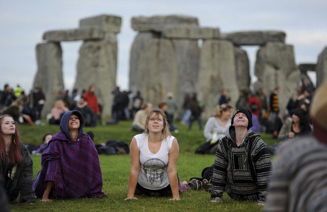 People perform yoga as they gather at the ancient stone circle Stonehenge, during the Summer Solstice, the longest day of the year, in Wiltshire Tuesday June 21, 2016. (Andrew Matthews/PA via AP)