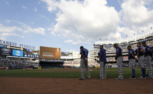 Members of the Texas Rangers stand at attention while observing a moment of silence for victims of the Istanbul airport attacks before the start of a baseball game against the New York Yankees in New York, Wednesday, June 29, 2016. (AP Photo/Kathy Willens)