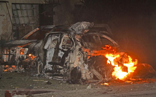 Vehicles burn at the scene a bomb attack on an hotel in Mogadishu, Somalia Wednesday, June 1, 2016. The attack took place on the Ambassador hotel, which is often frequented by government officials and business executives. (AP Photo/Farah Abdi Warsameh)