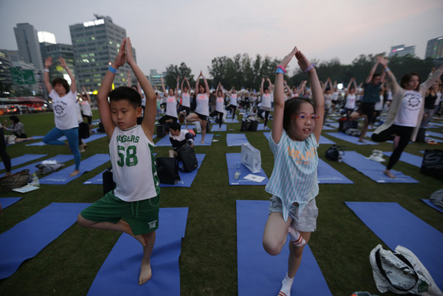 Children perform yoga to mark the International Day of Yoga in downtown Seoul, South Korea, Tuesday, June 21, 2016. (AP Photo/Ahn Young-joon)