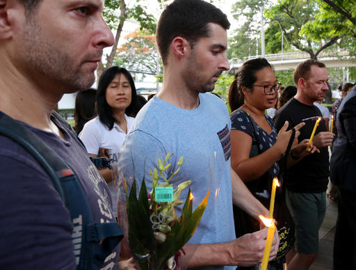 Visitors prepare to place candles at a vigil outside the US Embassy for those killed and wounded in the Sunday June 12, 2016 mass shooting at a gay nightclub in Orlando, Florida, in Bangkok, Thailand, Monday, June 13, 2016. The vigil was held for victims of the nightclub shooting which killed at least 50 people and was the deadliest U.S. mass shooting to date. (AP Photo/Mark Baker)