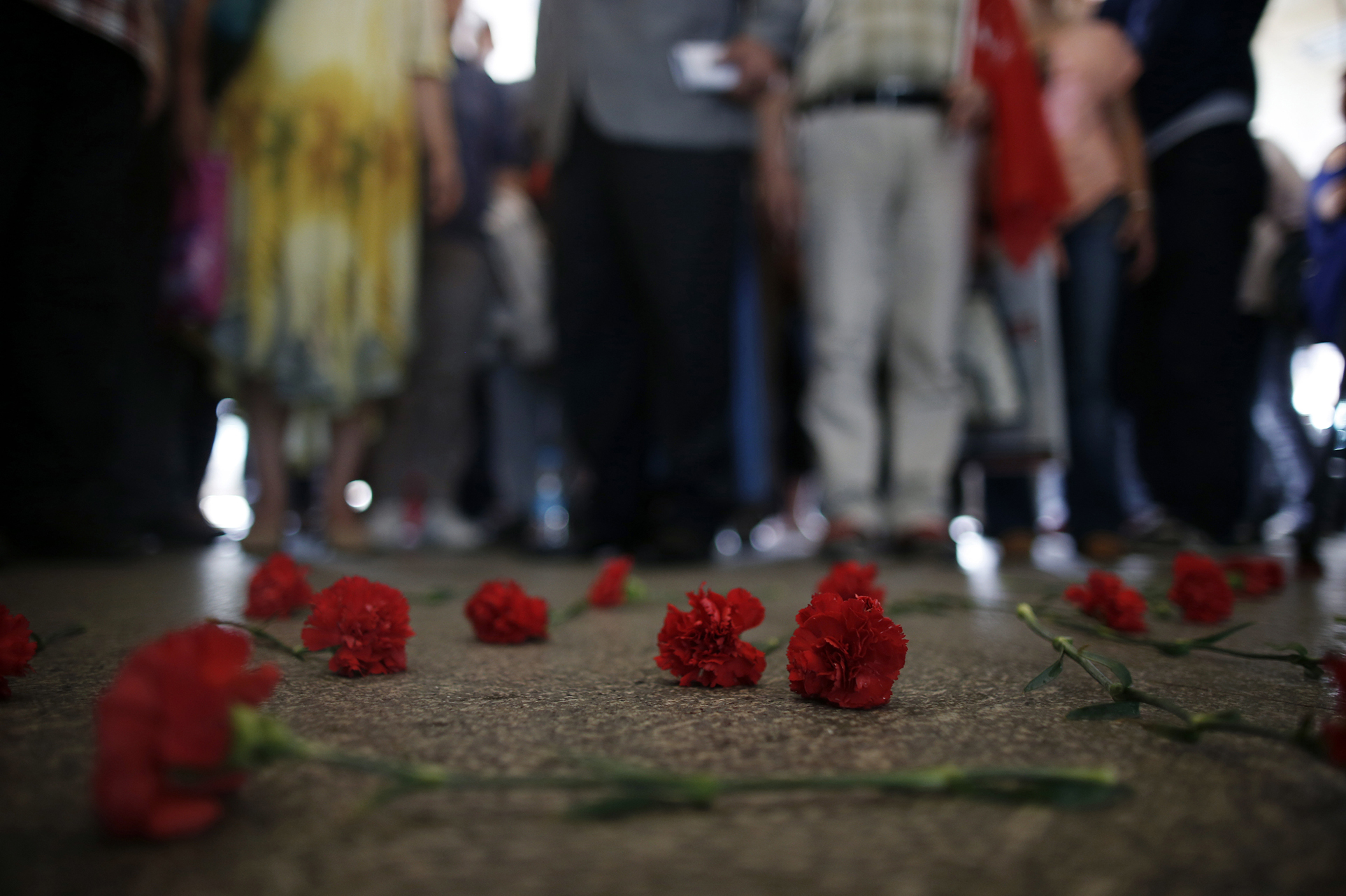 Colleagues leave carnations for Erol Eskisoy and Ali Zulfukar Yorulmaz, two taxi drivers killed in Tuesday's blasts at the entrance of Ataturk Airport in Istanbul, Thursday, June 30, 2016. A senior Turkish official on Thursday identified the Istanbul airport attackers as a Russian, Uzbek and Kyrgyz national hours after police carried out sweeping raids across the city looking for Islamic State suspects. (AP Photo/Emrah Gurel)