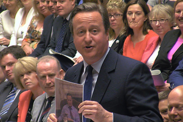 David Cameron displays a photo of himself and Larry the government's Chief Mouser (cat)
