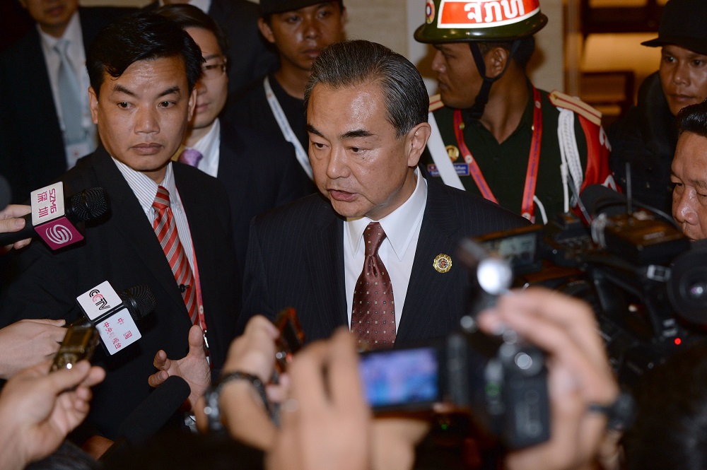 Chinese Foreign Minister Wang Yi (C) speaks to reporters after he met with US State Secretary John Kerry (not pictured) on the sideline of the Association of Southeast Asian Nations (ASEAN) annual ministerial meeting and the Regional Security Forum in Vientiane on July 25, 2016. Southeast Asian nations ducked direct criticism of Beijing over its claims to the South China Sea, in a diluted statement produced after days of disagreement that gives the superpower a diplomatic victory. / AFP PHOTO / HOANG DINH NAM