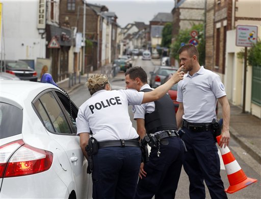 French police officers seal off one of the access to the scene of an attack in Saint-Etienne-du-Rouvray, Normandy, France, Tuesday, July 26, 2016. Two attackers invaded a church Tuesday during morning Mass near the Normandy city of Rouen, killing an 84-year-old priest by slitting his throat and taking hostages before being shot and killed by police, French officials said. (AP Photo/Francois Mori)
