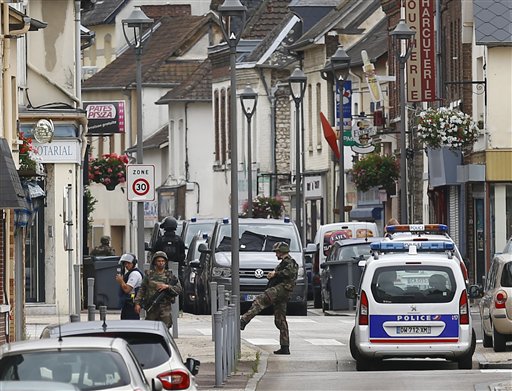 French soldiers stand guard near the scene of an attack in Saint-Etienne-du-Rouvray, Normandy, France, Tuesday, July 26, 2016. Two attackers invaded a church Tuesday during morning Mass near the Normandy city of Rouen, killing an 84-year-old priest by slitting his throat and taking hostages before being shot and killed by police, French officials said. (AP Photo/Francois Mori)