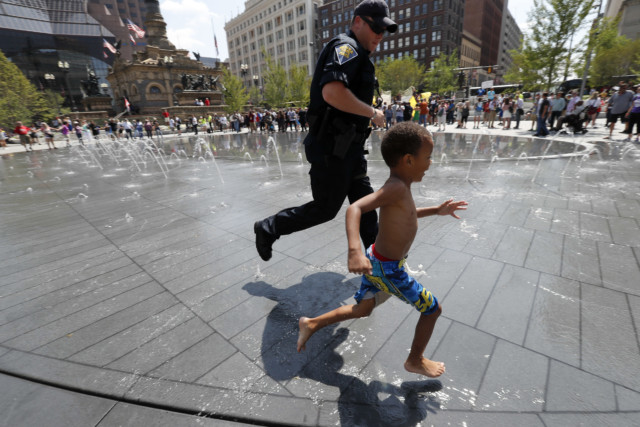 Police officer runs through fountain with child