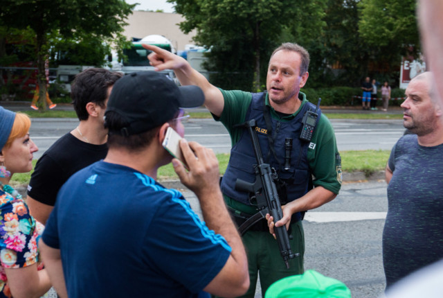 An officer tells people where to go following the shooting