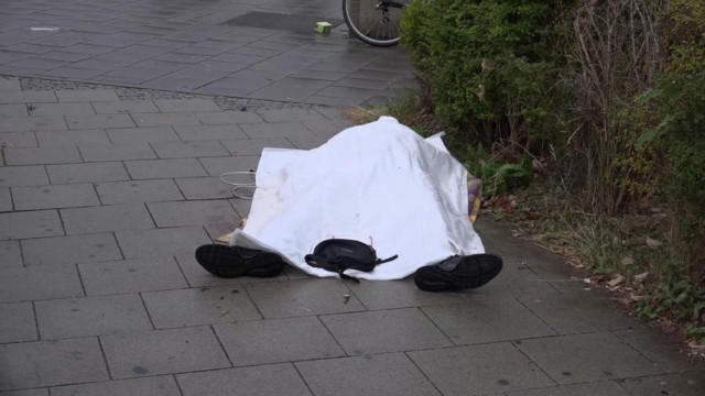 Body covered with a sheet outside a mall, in Munich, Germany,