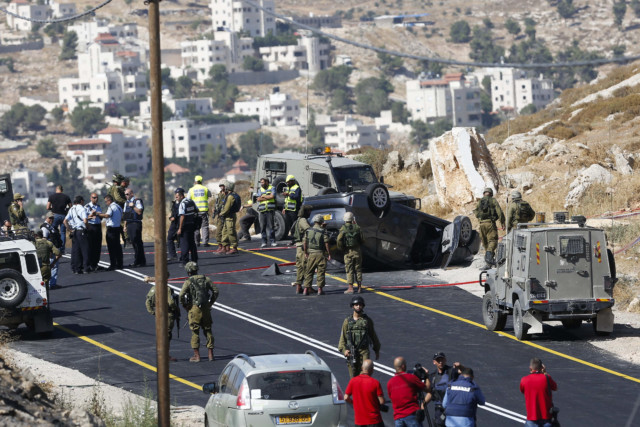 Israeli soldiers secure a road scene