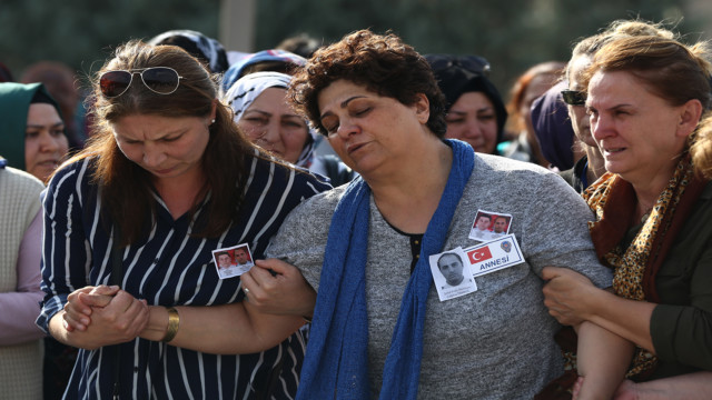 The mother of a Turkish policeman, center, is comforted by mourners during her son's funeral procession, in Ankara, Turkey, Wednesday, July 20, 2016. Turkey on Wednesday intensified a sweeping crackdown on the media, the military, the courts and the education system following an attempted coup, targeting tens of thousands of teachers and other state employees for dismissal in a purge that raised concerns about basic freedoms and the effectiveness of key institutions. (AP Photo/Hussein Malla)