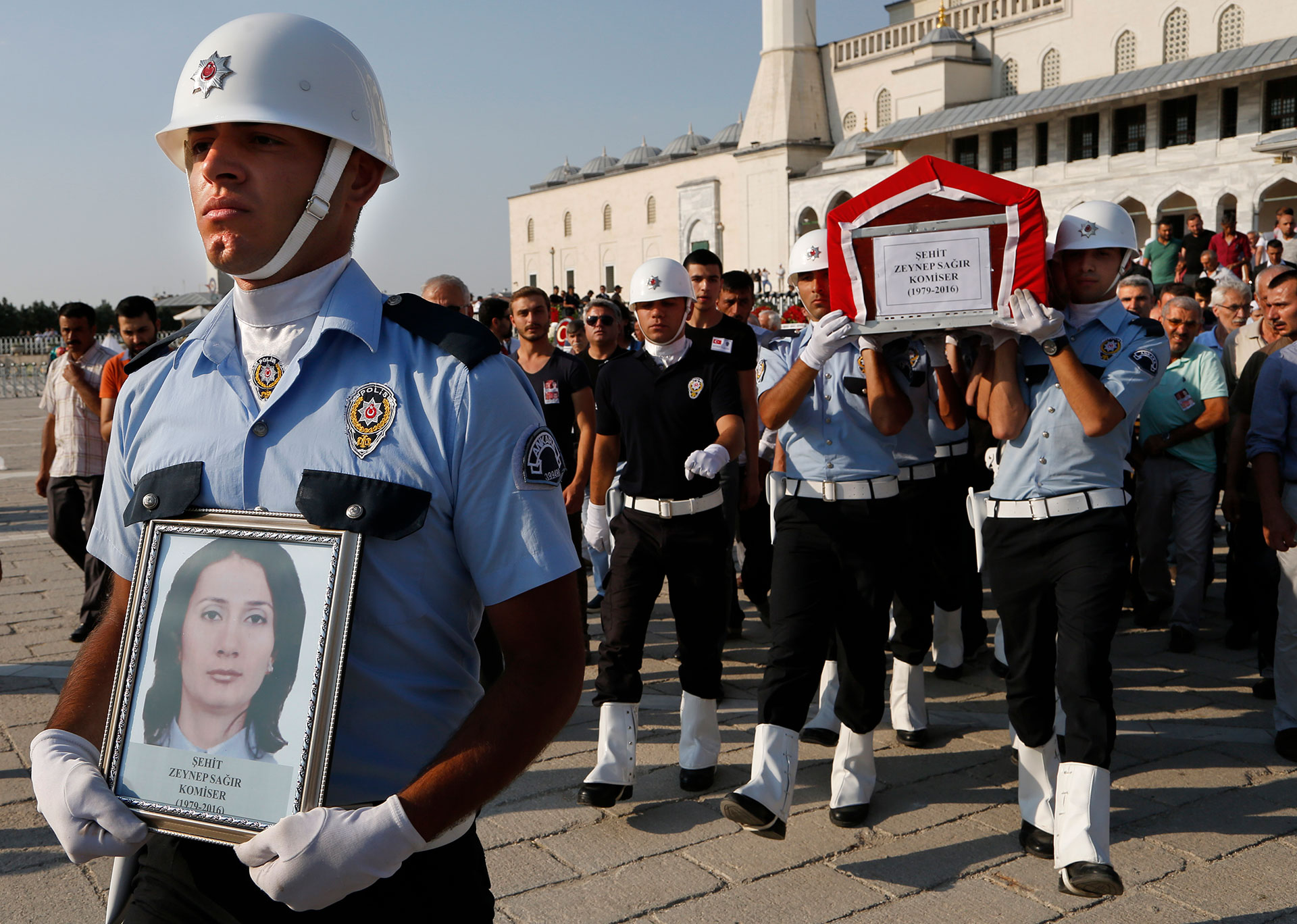 A Turkish honor guard carry the coffin of a policewoman killed Friday during the failed military coup, during a mass funeral in Ankara, Turkey, Monday, July 18, 2016. (AP Photo/Hussein Malla)