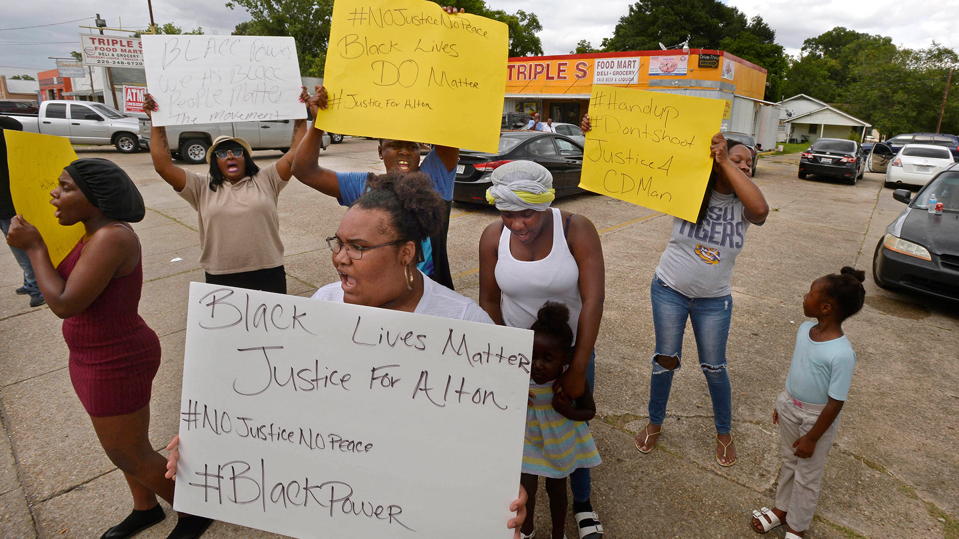 Family and friends of Alton Sterling, including his cousin Jakayla Sterling, foreground, protest on the corner of Fairfields Ave. and North Foster Drive, after Sterling was fatally shot in an altercation with Baton Rouge Police, Tuesday, July 5, 2016. (Travis Spradling/The Advocate via AP)