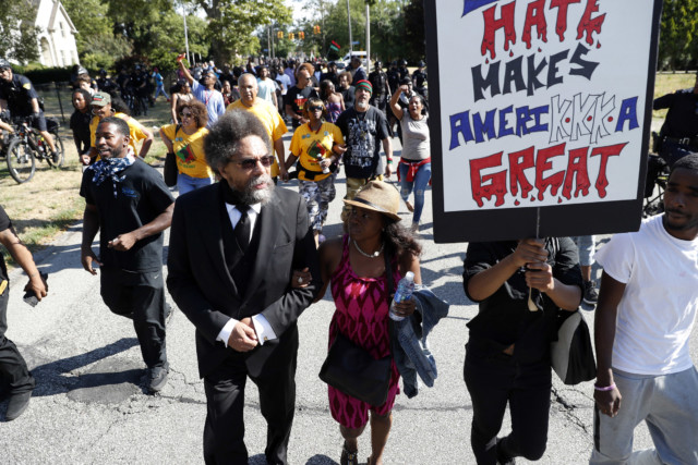 Cornel West walks in a march