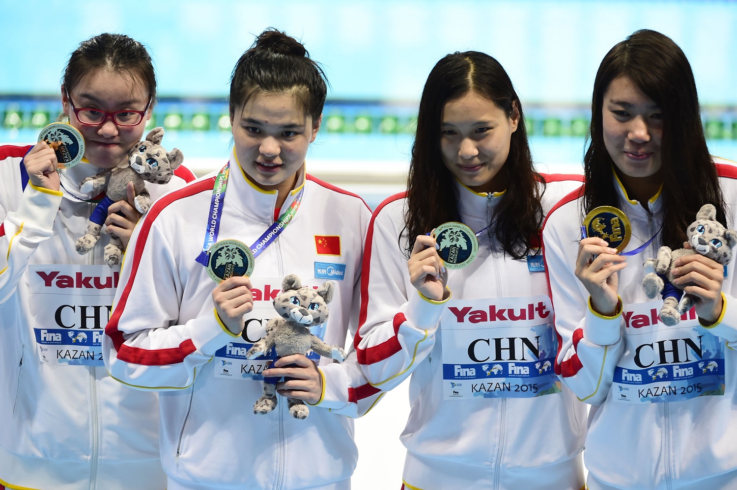 Team China celebrates its gold medal during the podium ceremony for the women's 4x100m medley relay swimming event at the 2015 FINA World Championships in Kazan on August 9, 2015. Shi Jinglin, Lu Ying, Fu YuanHui and Shen Duo competed in the event. AFP PHOTO / ALEXANDER NEMENOV, via VCG
