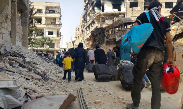 Syrian citizens carry their belonging
