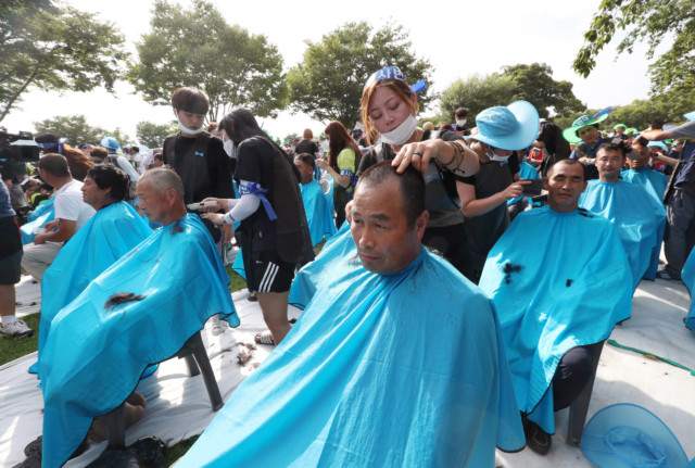 Residents have their heads shaved during a rally to oppose a plan to deploy an advanced U.S. missile defense system called Terminal High-Altitude Area Defense, or THAAD, in Seongju, South Korea, Monday, Aug. 15, 2016. (Kim Jun-beom/Yonhap via AP) KOREA OUT
