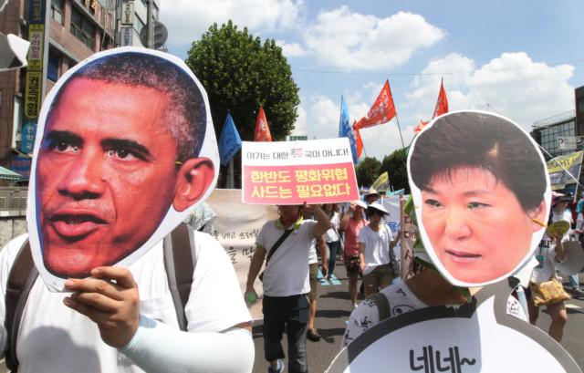South Korean protesters wearing masks of U.S. President Barack Obama and South Korean President Park Geun-hye, right, march to oppose a plan to deploy THAAD, in Seoul, South Korea, Monday, Aug. 15, 2016. (AP Photo/Ahn Young-joon)