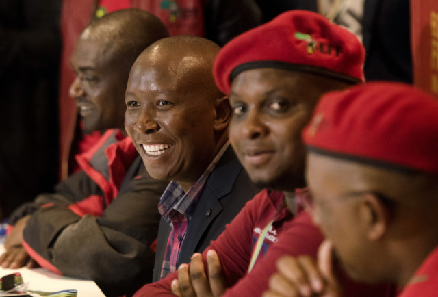 Leader of the Economic Freedom Fighters Julius Malema, centre, smiles during a news conference at the election results center in Pretoria, South Africa, Friday, Aug. 5, 2016. (AP Photo/Herman Verwey)