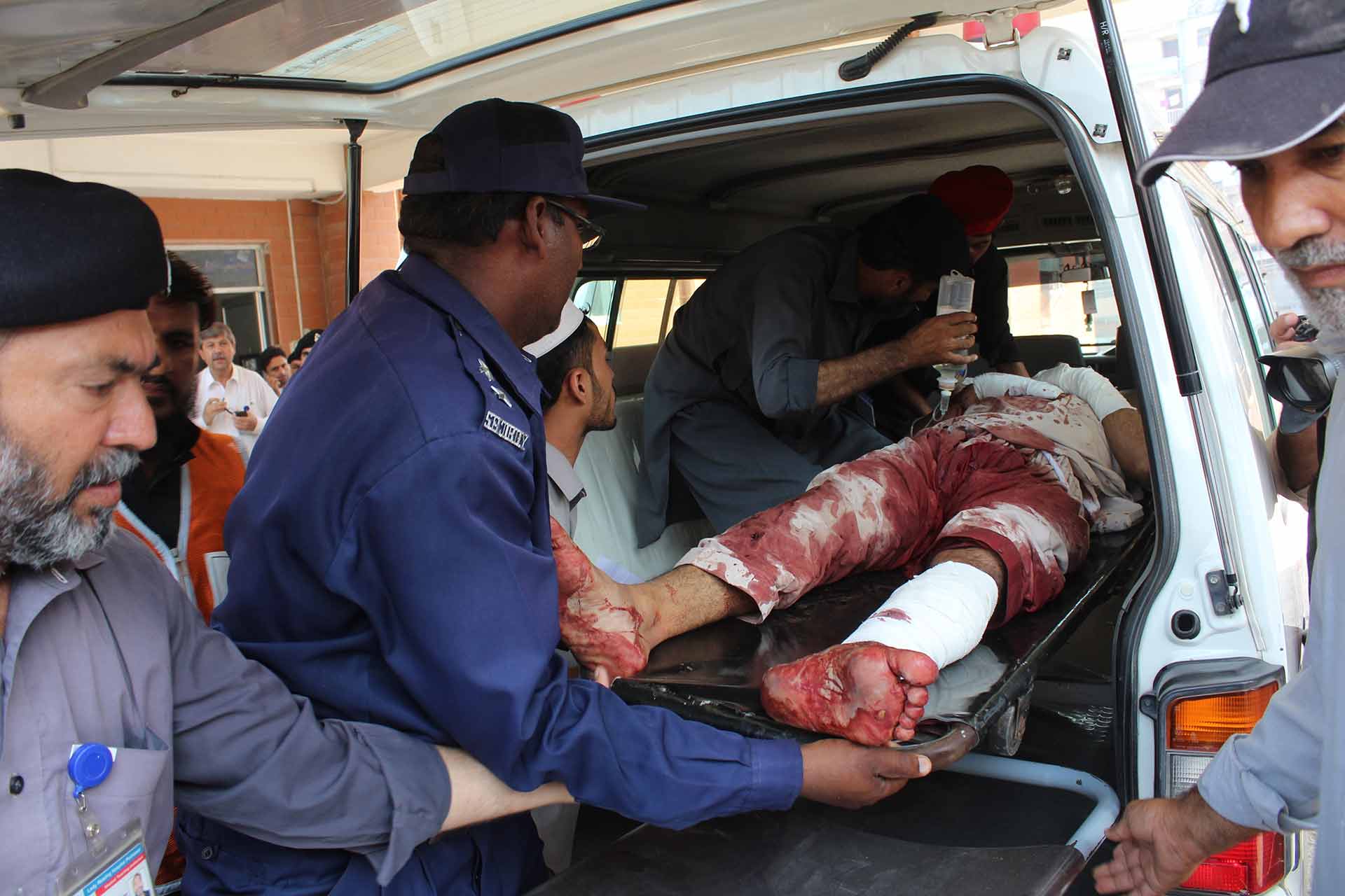 Pakistani volunteers carry an injured person arrived from Mardan, at a local hospital in Peshawar, Pakistan, Friday, Sept. 2, 2016. (AP Photo/Mohammad Sajjad)