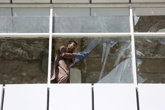 man cleans up broken glass