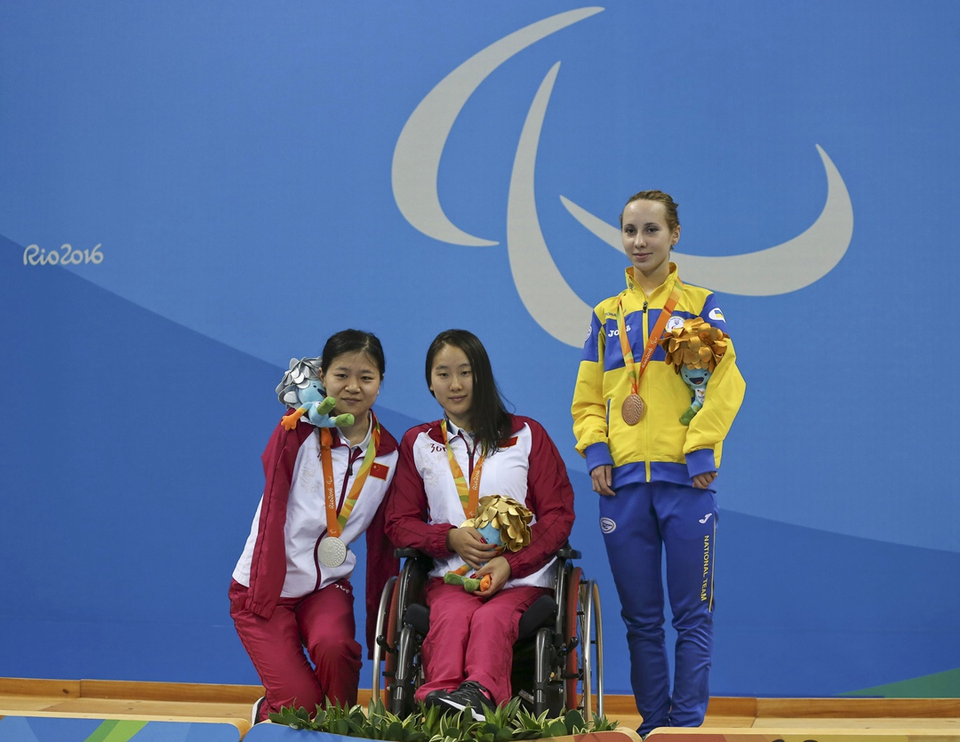 Lu Dong, Lingling Song of China and Oksana Khrul of Ukraine (L-R) react on the podium.  (REUTERS/Sergio Moraes)