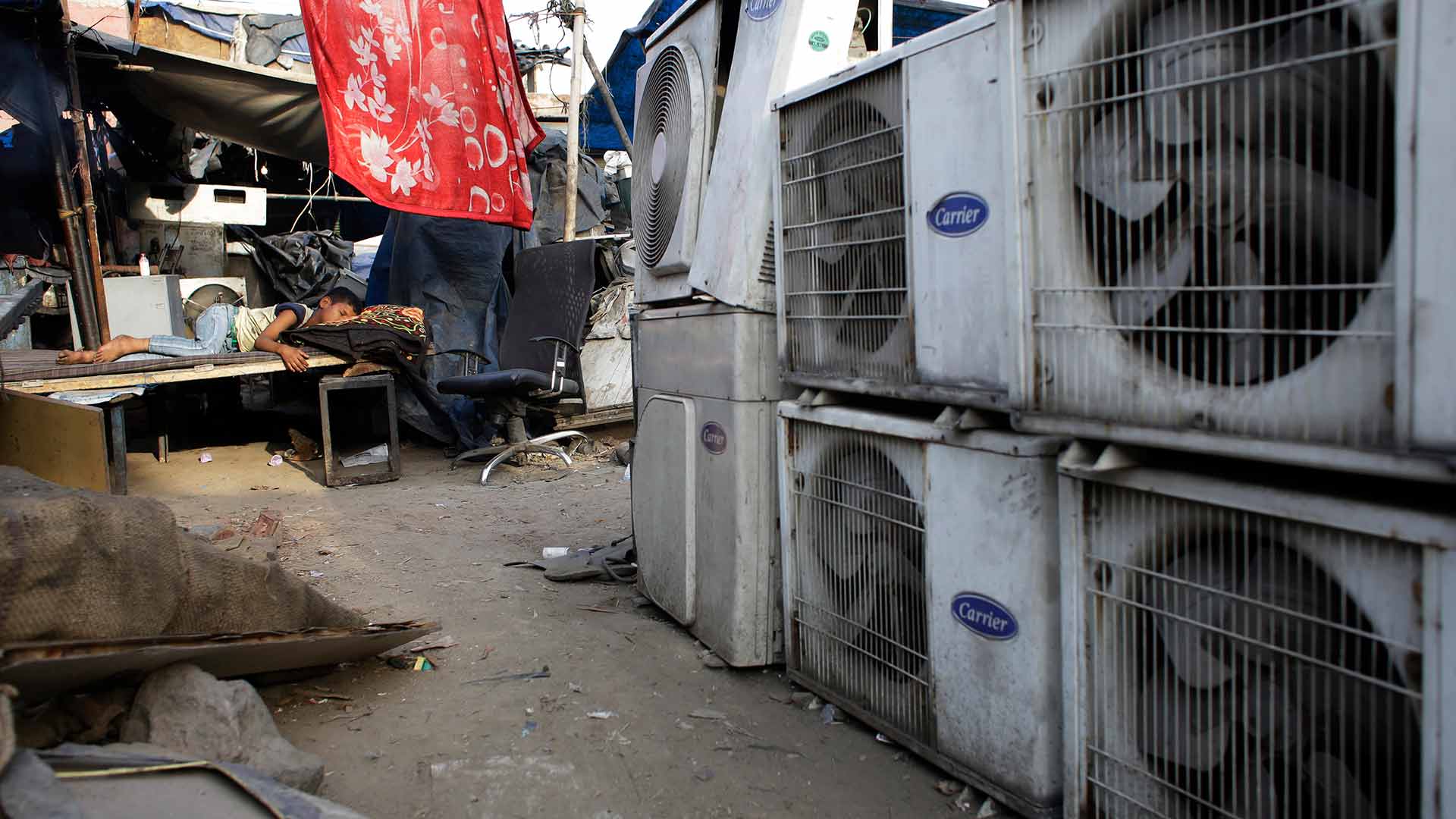 In this Tuesday, May 17, 2016 file photo, an Indian boy of a migrant daily wageworker sleeps in scorching summer temperatures near an air conditioner shop at a marketplace in New Delhi, India. Nations reached a deal Saturday, Oct. 15, 2016 to limit the use of hydrofluorocarbons, or HFCs - greenhouse gases far more powerful than carbon dioxide that are used in air conditioners and refrigerators, in a major effort to fight climate change. (AP Photo/Altaf Qadri, File)