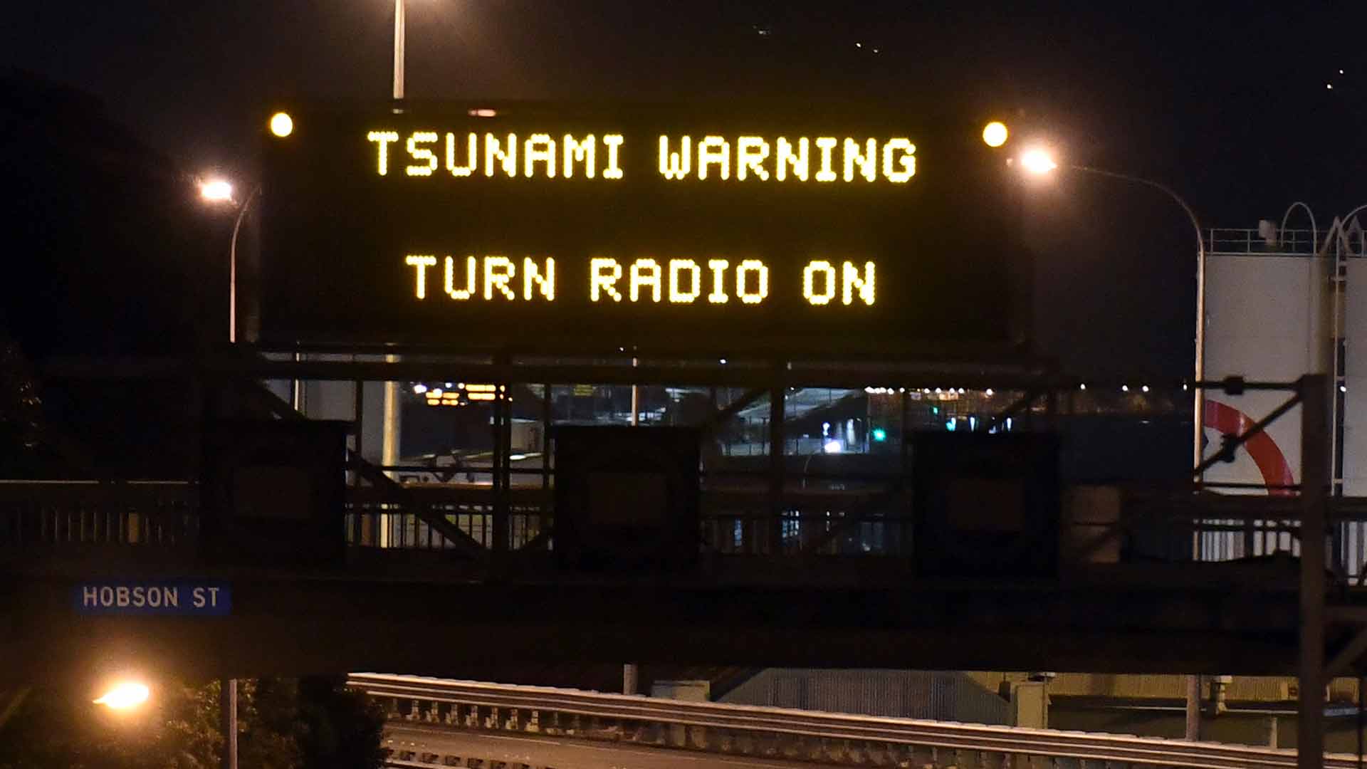 Motorway sign warning of Tsunami, in Wellington, Monday, Nov. 14, 2016, after a major earthquake struck New Zealand's south Island early Monday.  A powerful earthquake struck in a mostly rural area close to the city of Christchurch but appeared to be more strongly felt in the capital, Wellington, more than 200 Km (120 miles) away. (Ross Setford/SNPA via AP)