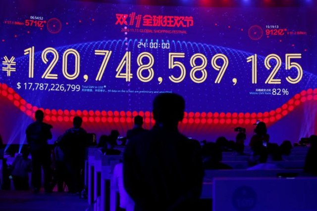 People watch a screen displaying the total value of goods sold during Alibaba Group's 11.11 Singles' Day global shopping festival in Shenzhen