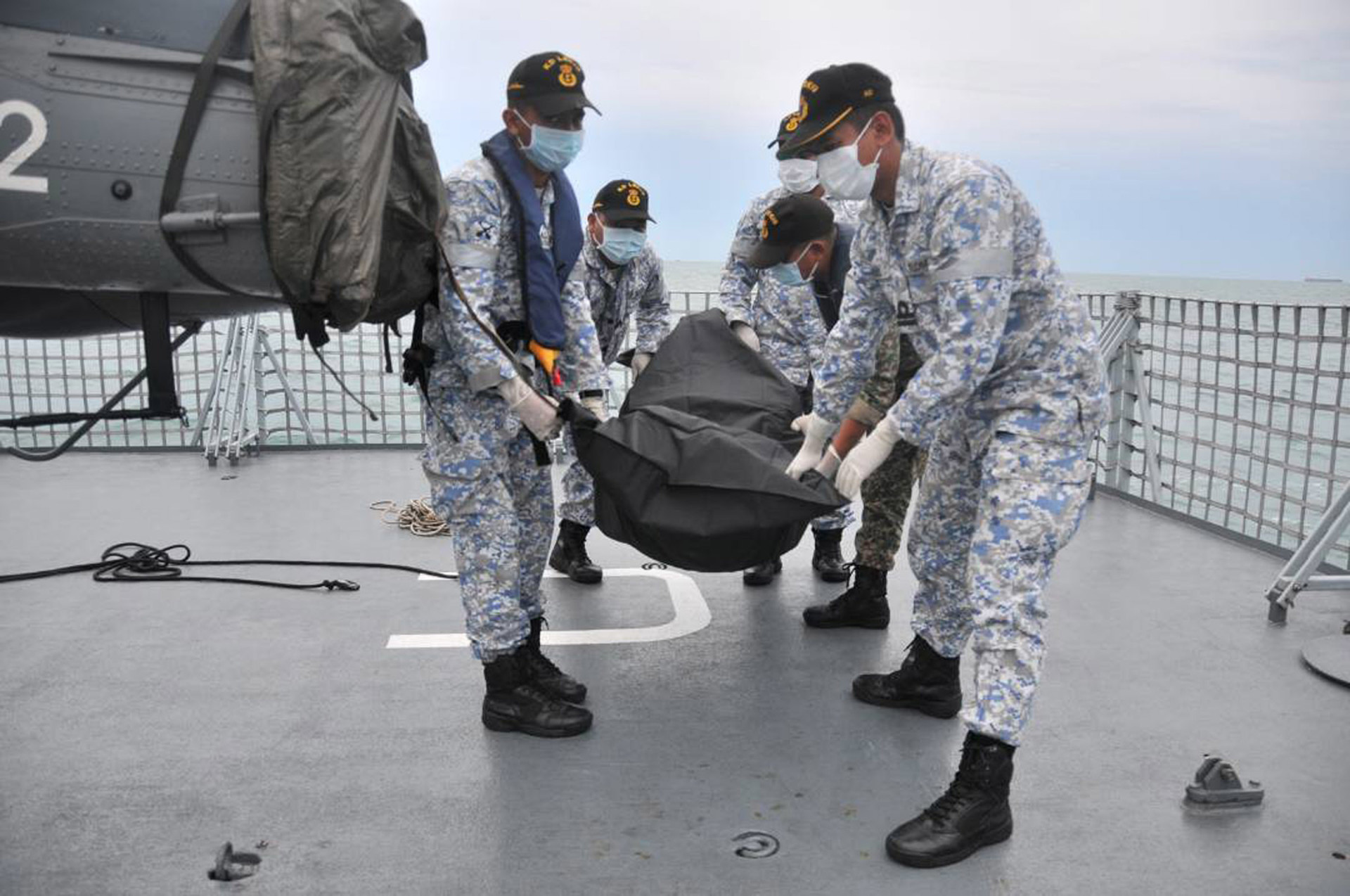 navy sailors carry an unidentified body