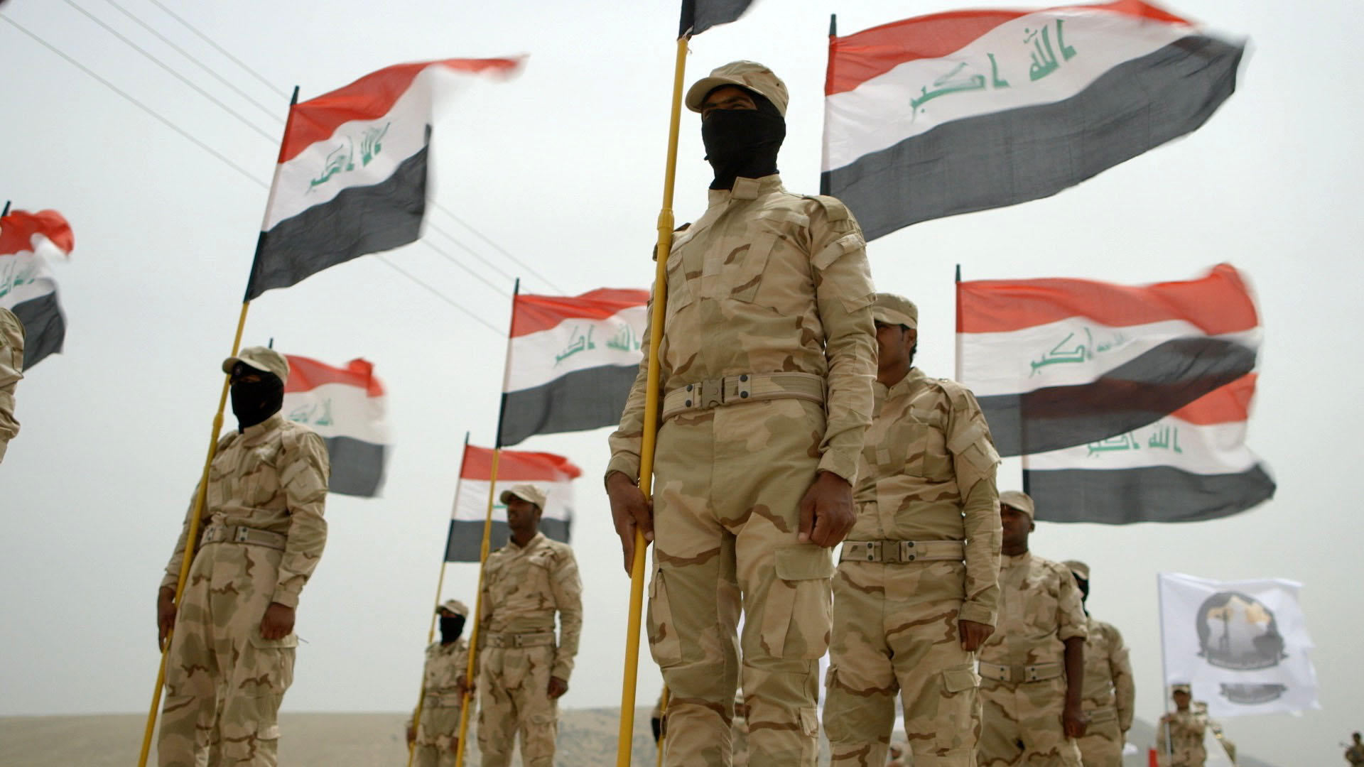 At a military graduation in Nineveh, Iraqi soldiers wear masks for fear of retribution, should they be recognized.