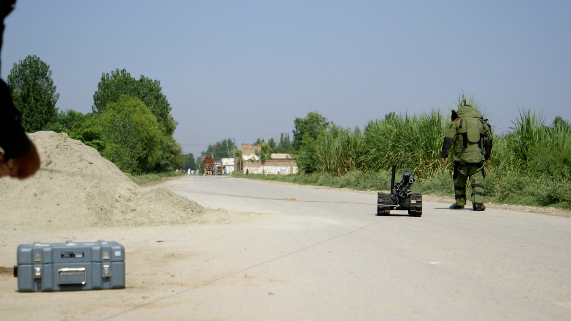 A bomb technician works to disassemble a roadside explosive left by the TTP.