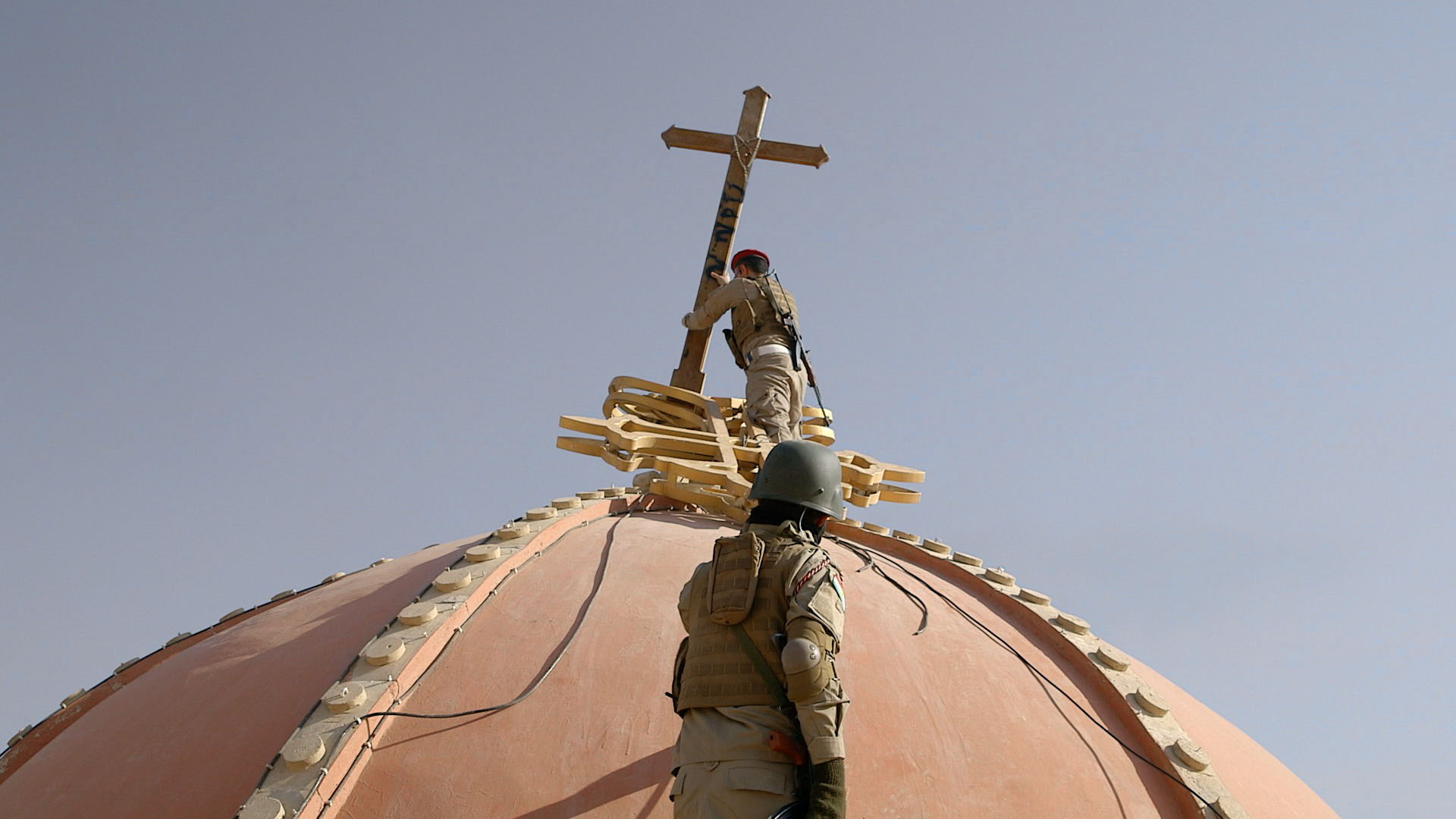 In Qaraqosh, a cross is returned to a Cathedral’s dome, by a unit of Kurdish Muslims.
