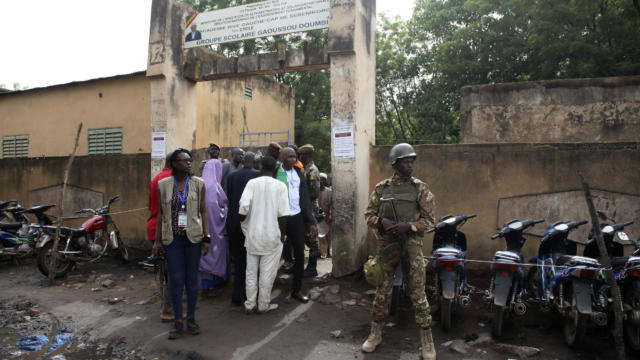 Security men stand guard in front of a polling station