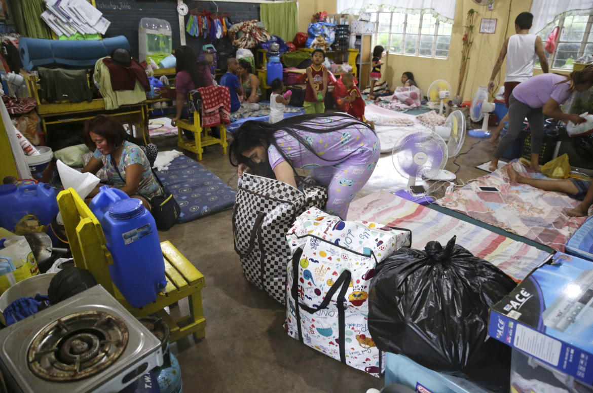 evacuee fixes her bag inside a temporary evacuation center