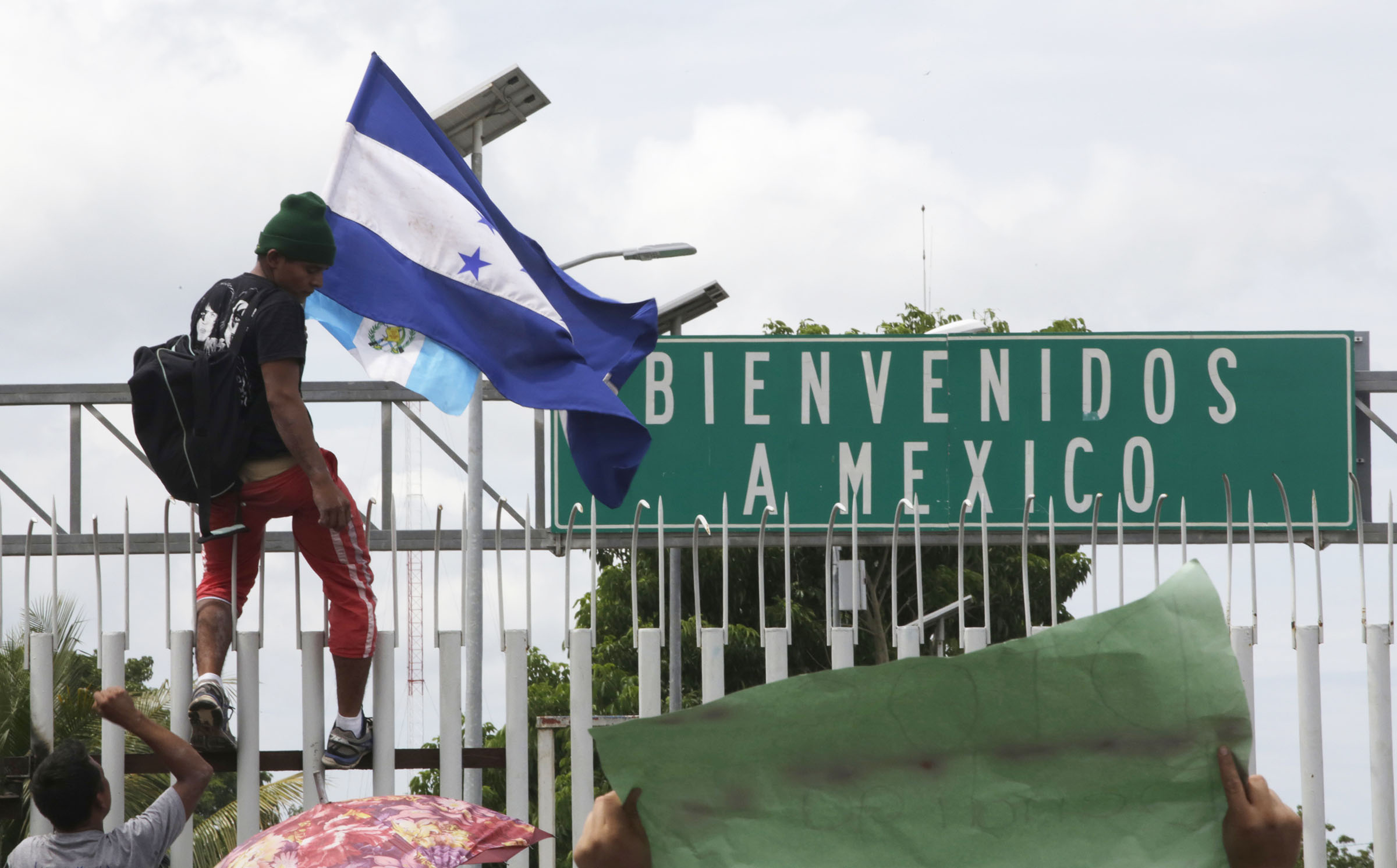 Migrants force through fence as they try to cross border into Mexico