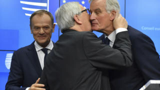 President Jean-Claude Juncker, center, kisses European Union chief Brexit negotiator Michel Barnier