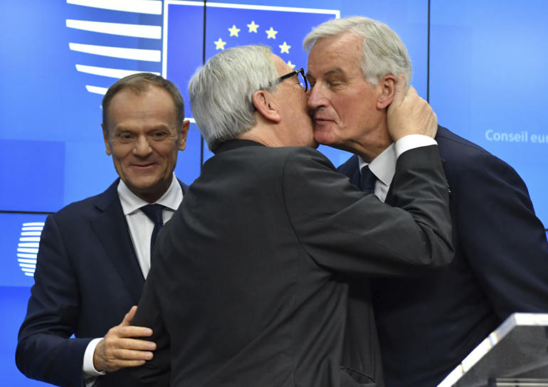 President Jean-Claude Juncker, center, kisses European Union chief Brexit negotiator Michel Barnier