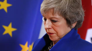 British Prime Minister Theresa May walks past the EU flag