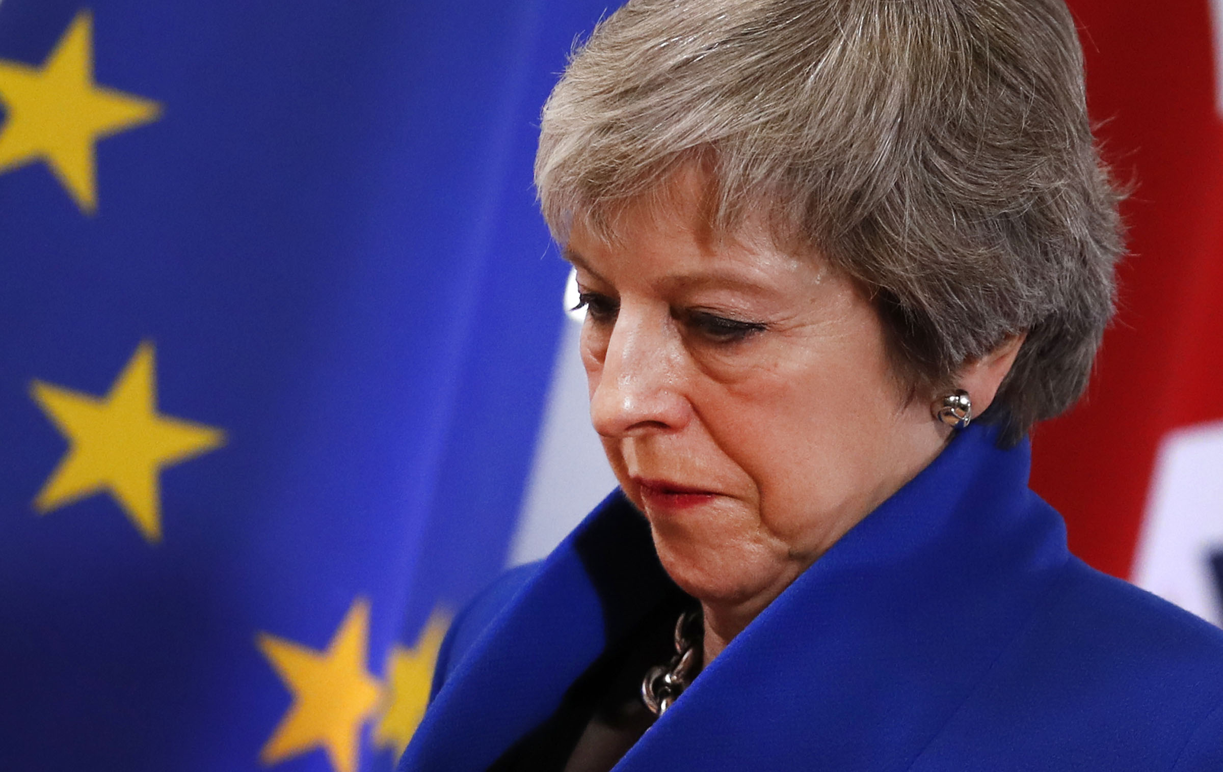 British Prime Minister Theresa May walks past the EU flag