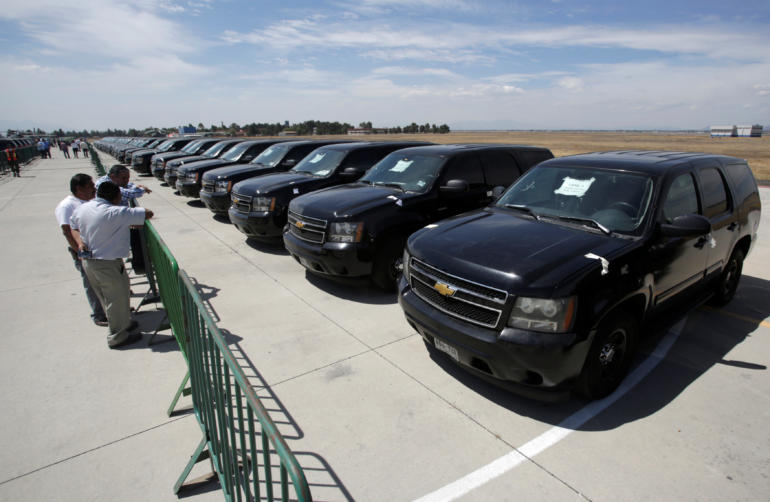 People observe part of the fleet of government vehicles during an auction organized by the federal government at Santa Lucia military base on the outskirts of Mexico City
